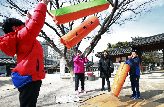 설 연휴 첫날인 15일 오후 서울 종로구 안국동 운현궁에서 시민들이 윷놀이 체험을 즐기고 있다.
